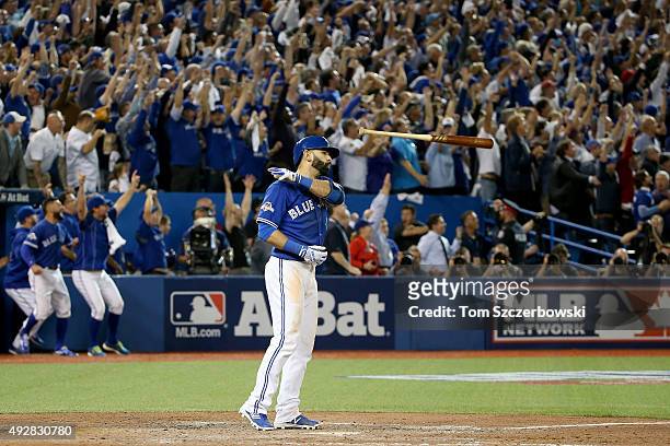 Jose Bautista of the Toronto Blue Jays flips his bat up in the air after he hits a three-run home run in the seventh inning against the Texas Rangers...