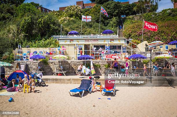 seaside cafe on crowded beach tourists sunbathers and families england - waterfront cafe stock pictures, royalty-free photos & images