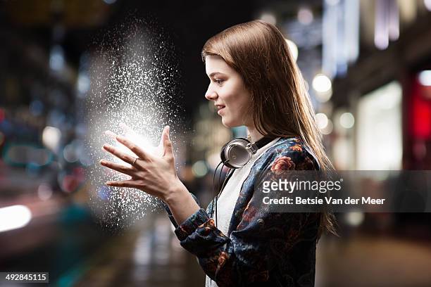 teenage girl looks at energy source between hands. - übersinnliches stock-fotos und bilder