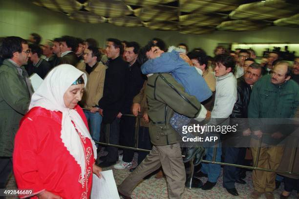 An overjoyed father embracing his child, among the group of released hostages from the Airbus hijacked by Algerian Islamic militants, arrives at Orly...