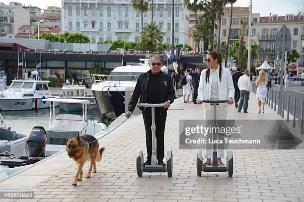 Roberto Cavalli and Lina Nilson ride on segways on day 8 of the 67th Annual Cannes Film Festival on May 21, 2014 in Cannes, France.