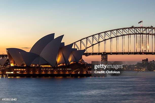city von sydney opera house und der harbour bridge in der abenddämmerung - hafenbrücke von sydney stock-fotos und bilder