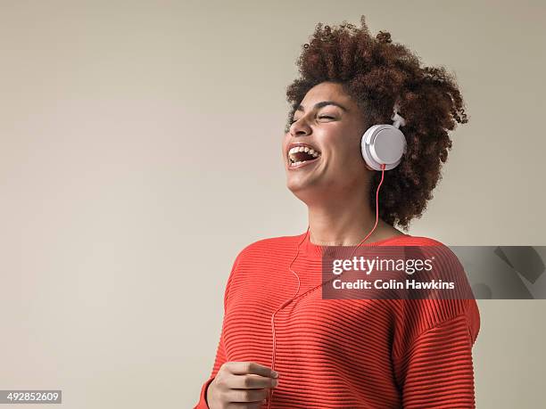 young black female wearing headphones laughing - headphones woman stock-fotos und bilder