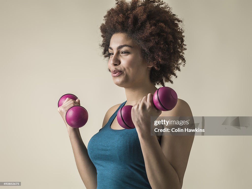 Young black female excercising with weights