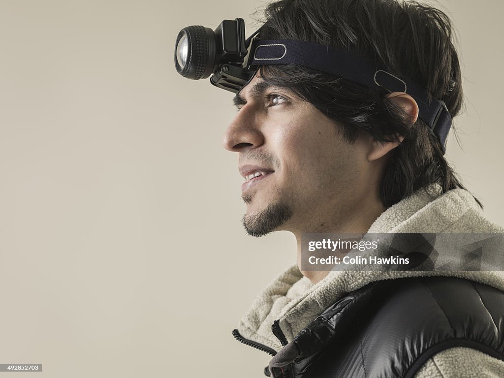 Asian man wearing head torch