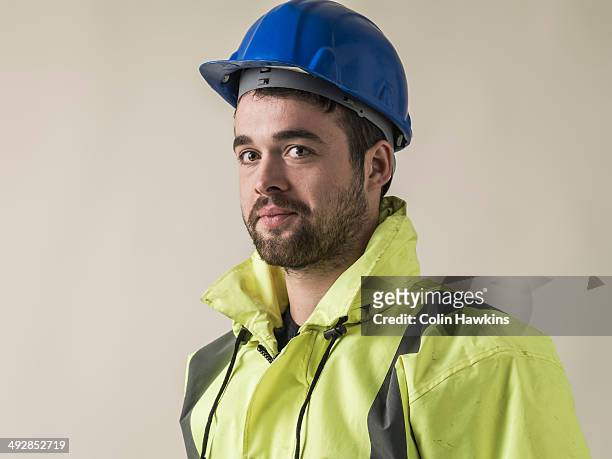 man wearing safety helmet - construction worker pose imagens e fotografias de stock