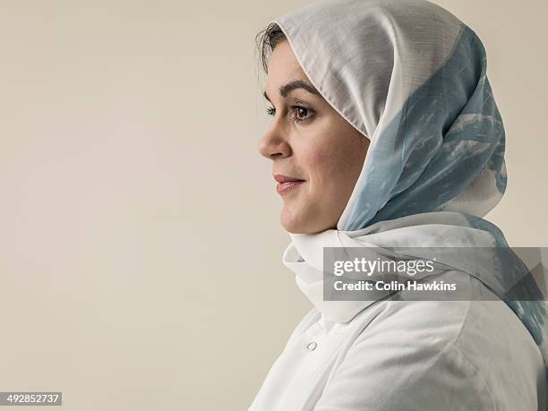 woman wearing laboratory coat and hijab head scarf - woman hijab stock pictures, royalty-free photos & images