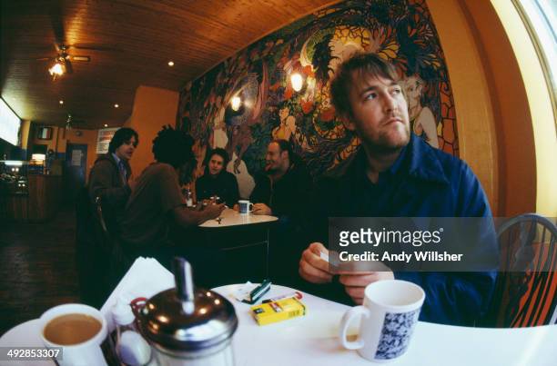 Singer-songwriter Guy Garvey in a cafe with the other members of English alternative rock group Elbow, December 2000. Left to right: keyboard player...