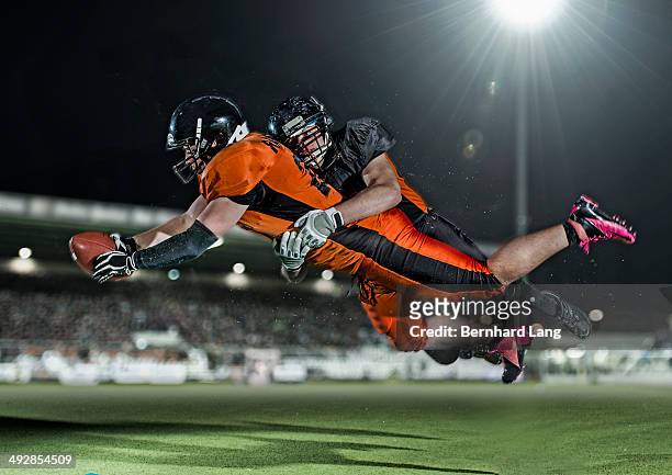 american football player tackling opponent - tackling stockfoto's en -beelden