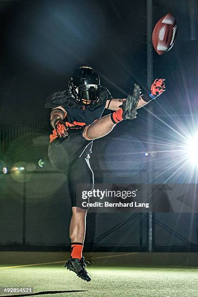american football player kicking football - offensive tackle american football player stock-fotos und bilder
