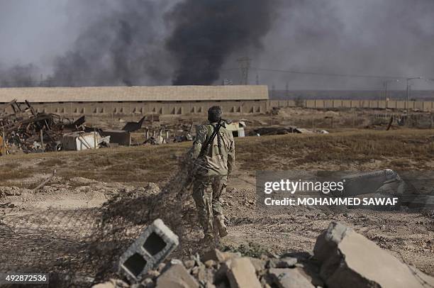 An Iraqi Shiite fighter from the Popular Mobilisation units, fighting alongside Iraqi forces, walks in the town of Baiji north of Tikrit, during...