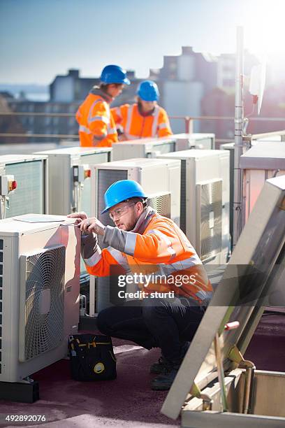 air conditioning installation on rooftop - rooftop hvac stock pictures, royalty-free photos & images