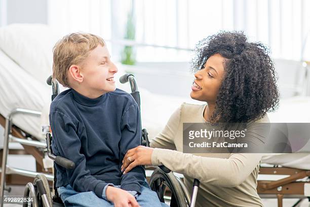 caregiver talking to little boy - special needs children stock pictures, royalty-free photos & images