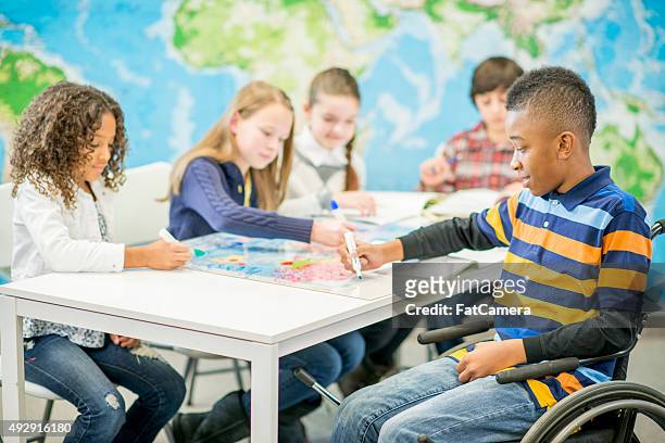 children coloring a world map - special needs children stock pictures, royalty-free photos & images