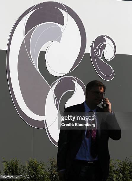 Visitor speaks on a mobile phone outside the OAO Rostelecom corporate pavilion at the St. Petersburg International Economic Forum in Saint...