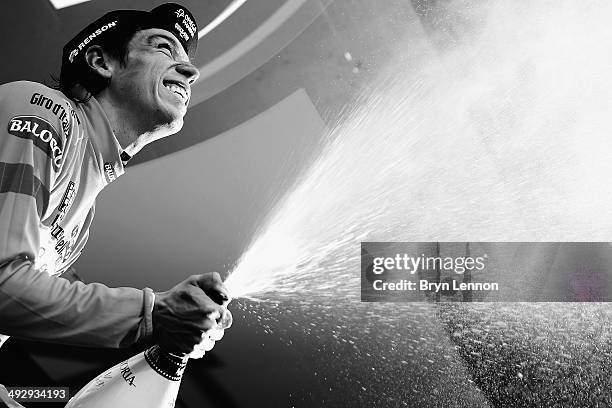 Stage winner and new race leader and wearer of the Maglia Rosa Rigoberto Uran of Colombia and Omega Pharma-Quickstep celebrates and sprays prosecco...