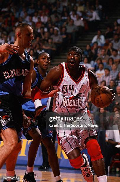 Hakeem Olajuwon of the Houston Rockets drives past Zydrunas Ilgauskas of the Cleveland Cavaliers during the game on October 31, 1997 at the Compaq...