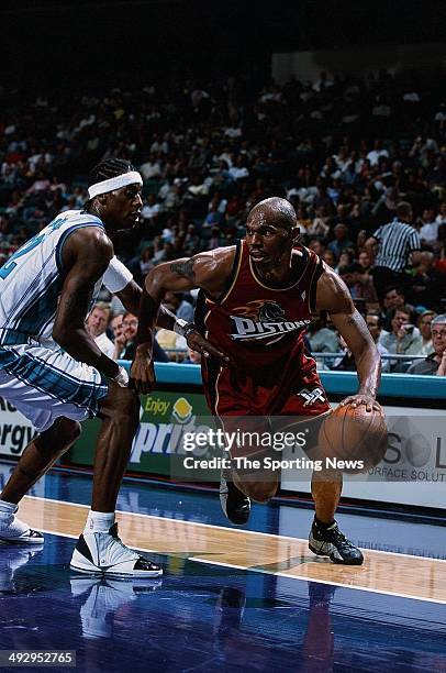 Jerry Stackhouse of the Detroit Pistons drives to the basket past Eddie Robinson of the Charlotte Hornets during the game on April 7, 2001 at...