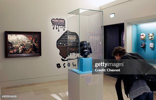 Visitor looks at a mask of the Star Wars character Darth Vader during the exhibition "Mythes Fondateurs : D'Hercule a Dark Vador" at Petite Galerie...