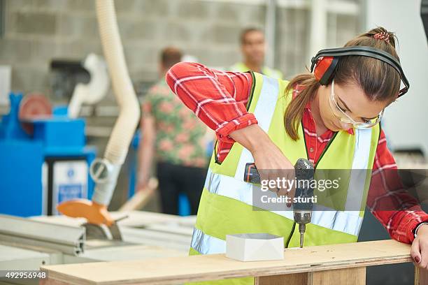 female carpenter screwing her work together - wood working stock pictures, royalty-free photos & images