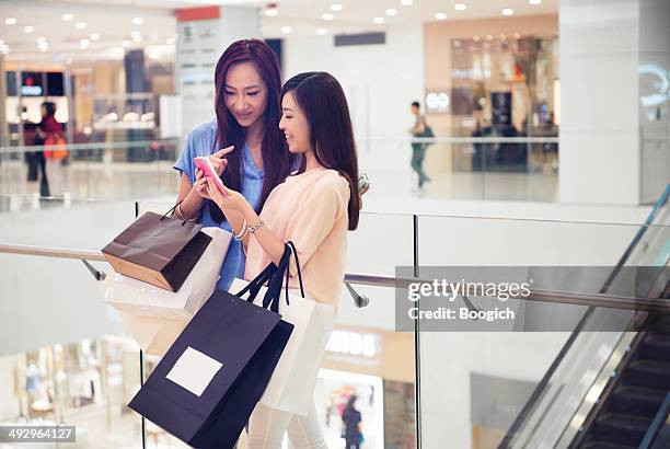 friends update social media status in hong kong luxury mall - woman shopping china stock pictures, royalty-free photos & images