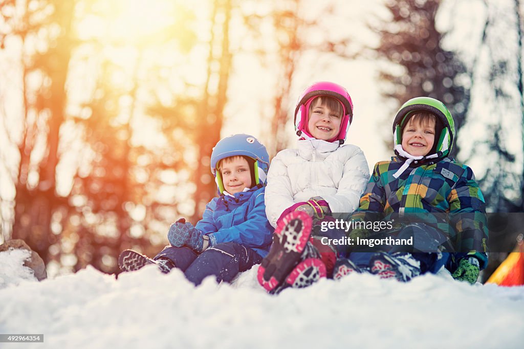 Happy kids in ski outfits enjoying winter