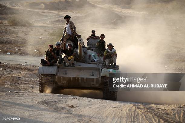 Iraqi Shiite fighters from the Popular Mobilisation units, fighting alongside Iraqi forces, ride on a tank in the town of Baiji north of Tikrit,...