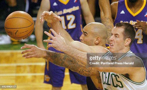 Chris Ayer of the Red Claws, right, and Robert Sacre of the LA D-Fenders reach for a loose ball during the Red Claws home opener on Friday, November...