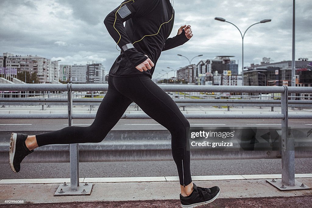 Young fit man running and listening to music