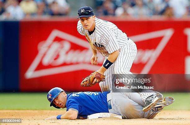 Stephen Drew of the New York Yankees in action against Cliff Pennington of the Toronto Blue Jays at Yankee Stadium on September 12, 2015 in the Bronx...