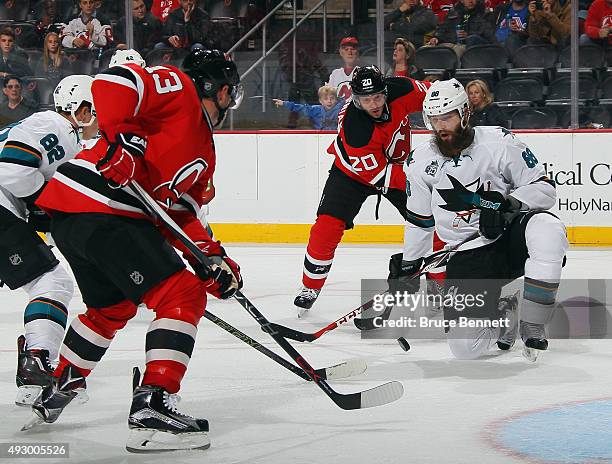 Mike Cammalleri and Lee Stempniak of the New Jersey Devils converge on Brent Burns of the San Jose Sharks during the second period at the Prudential...