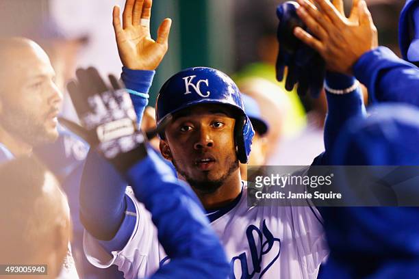 Alcides Escobar of the Kansas City Royals is congratulated by teammates in the dugout after scoring a run in the third inning against the Toronto...