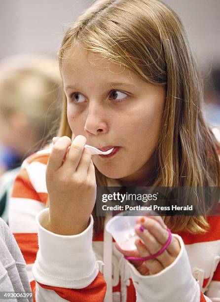 Olivia Raymond, a fourth grader at Sea Road School in Kennebunk, tries the culinary creation of Jonathan Cartwright, which was a sweet potato pancake...