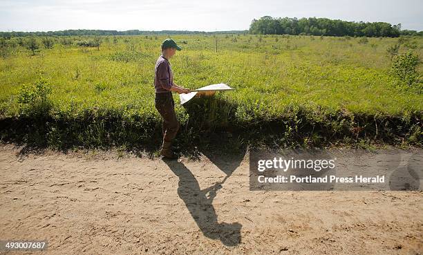 Melanie Renell uses a flag - a square piece of corduroy attached to a broom stick - to gather ticks in the woods at the Kennebunk Plains in Kennebunk...