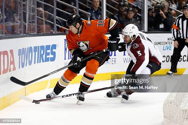 Tim Jackman of the Anaheim Ducks and Nate Guenin of the Colorado Avalanche skate to the puck during the first period of a game at Honda Center on...