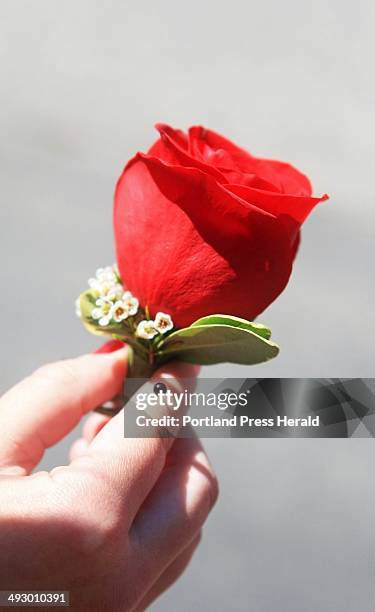 Mackenzie Leighton, a junior at Cape Elizabeth High School, holds the boutonniere she bought at Fiddleheads in South Portland for her date, Connor...