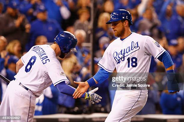 Ben Zobrist of the Kansas City Royals high fives Mike Moustakas of the Kansas City Royals after scoring a run in the eighth inning against the...