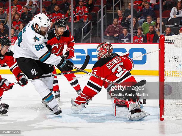 Brent Burns of the San Jose Sharks is stopped on a close in shot by Cory Schneider of the New Jersey Devils during the game at the Prudential Center...
