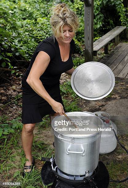 Friday, July 27, 2012. Courtney MacIsaac, owner of The Maine Lobsterbake Company, stirs the clam chowder, the first course in the full Downeast...