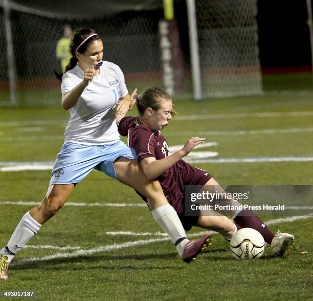 Elise Flathers of Cape Elizabeth High School, right, slides for the ball as Ciera Berthiaume of Windham High School defends in the first-half of...