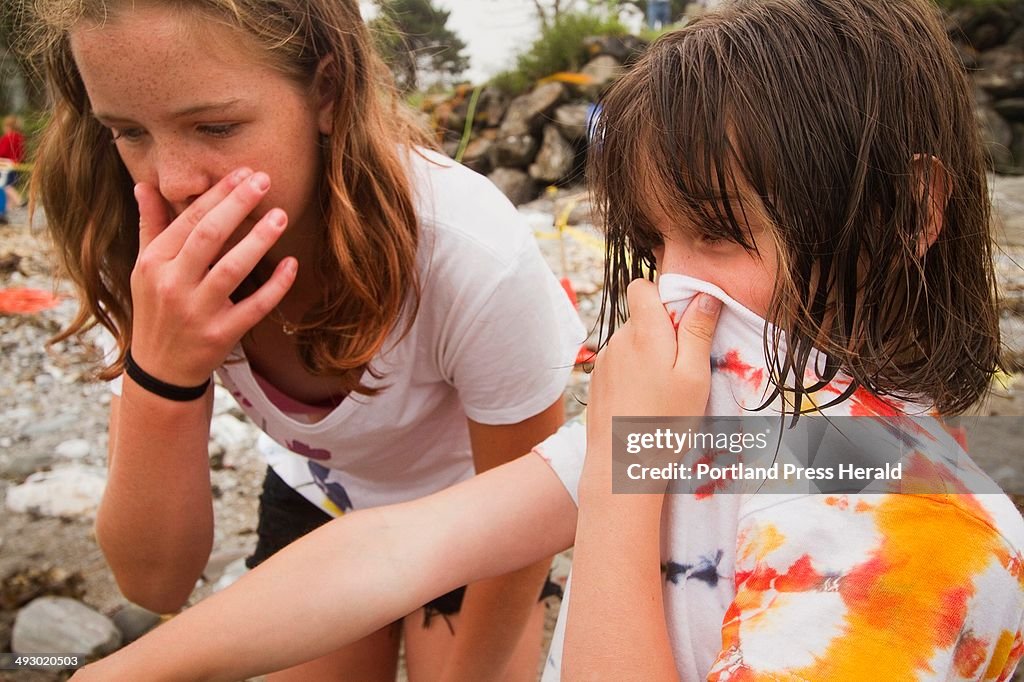 Six-year-old Emily Pierce (R) and her sister Maggie, 12 of Cape Elizabeth, shield their noses from t
