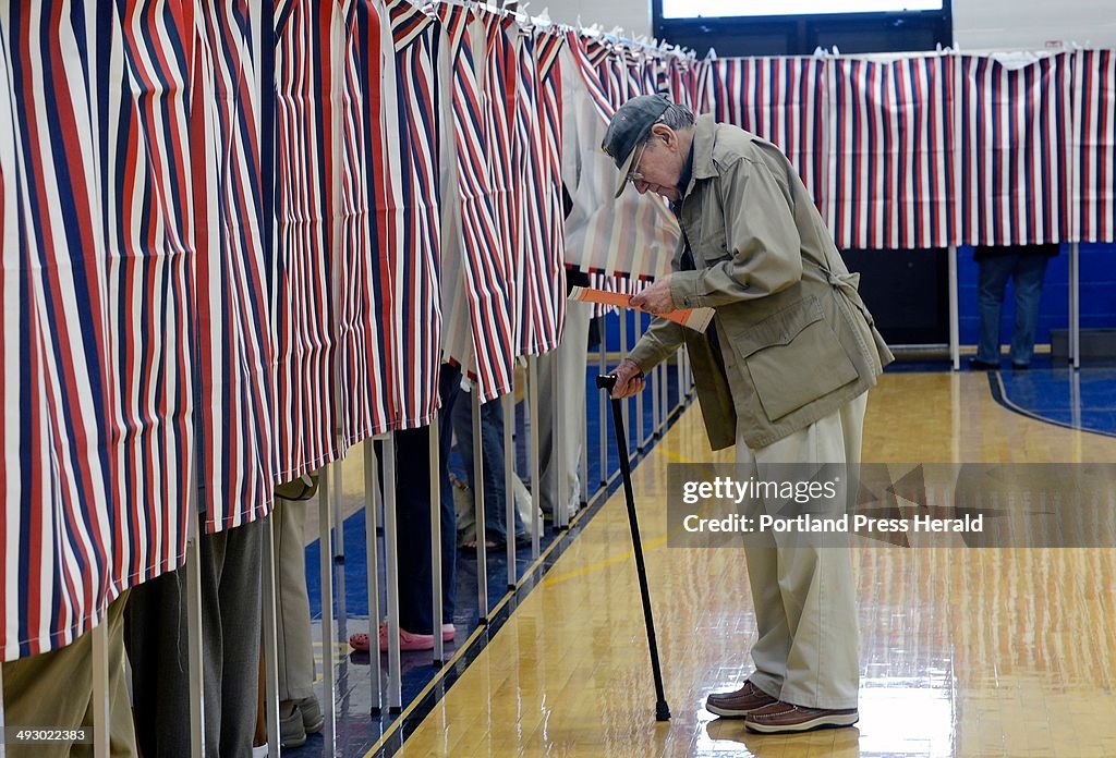 Richard Carbonneau 84, of Old Orchard Beach looks over the ballot before entering a voting booth at 