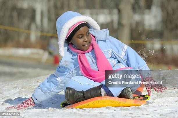 Diana Aboda slows herself down after a fast slide down the Payson Park hill at the WinterKids event. --