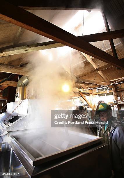 Jimmy Pak of Biddeford watches on Saturday as sap is boiled in the evaporator at Cole Farm in Dayton. The boiling evaporates the water in the sap,...