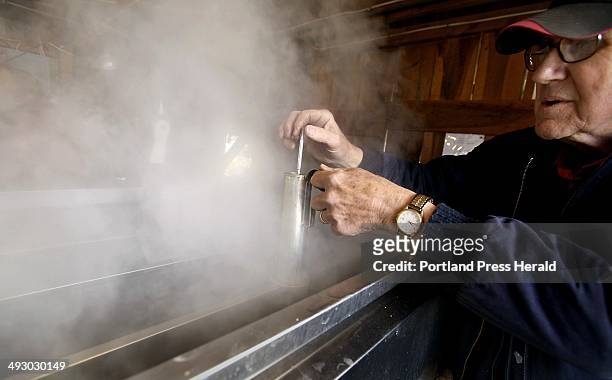 Clark Cole uses a hydrometer to measure the density of the syrup in the evaporator in his family's sugarhouse at Cole Farm in Dayton. --