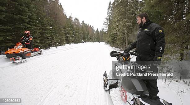 Ryan Harvey of Sanford, right, watches Drew Adams move to the side of a trail in Oquossoc on Saturday, January 12, 2013. Harvey thinks that Maine's...