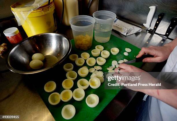 Sous chef Skye Bonney of The Black Birch cuts eggs as she prepares deviled eggs Wednesday, March 20, 2013.