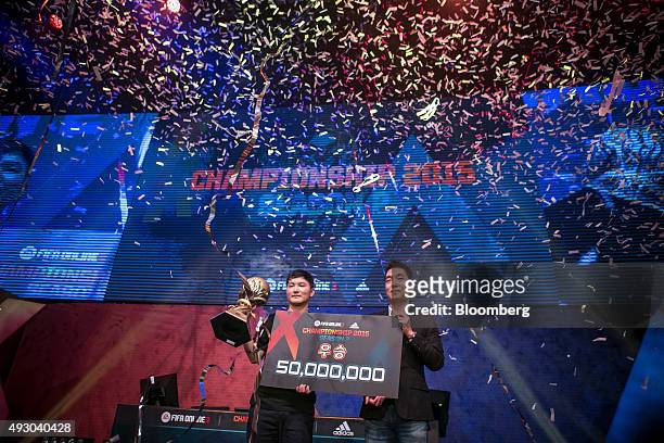 Yang Jin Hyeob, left, a professional video-game player, accepts a cash prize from Park Jeong-mu, project director of Nexon Korea, after winning the...