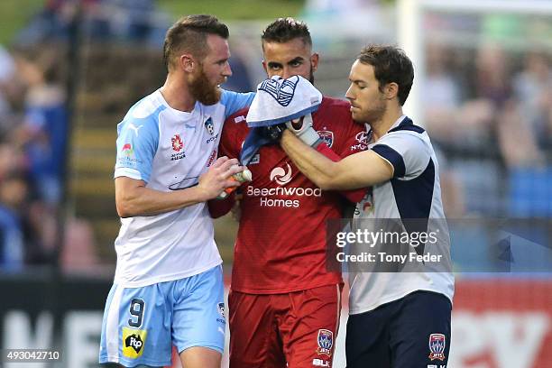 Mark Birighitti of the Jets leaves the ground after getting injured he is aided by Shane Smeltz of Sydney FC during the round two A-League match...