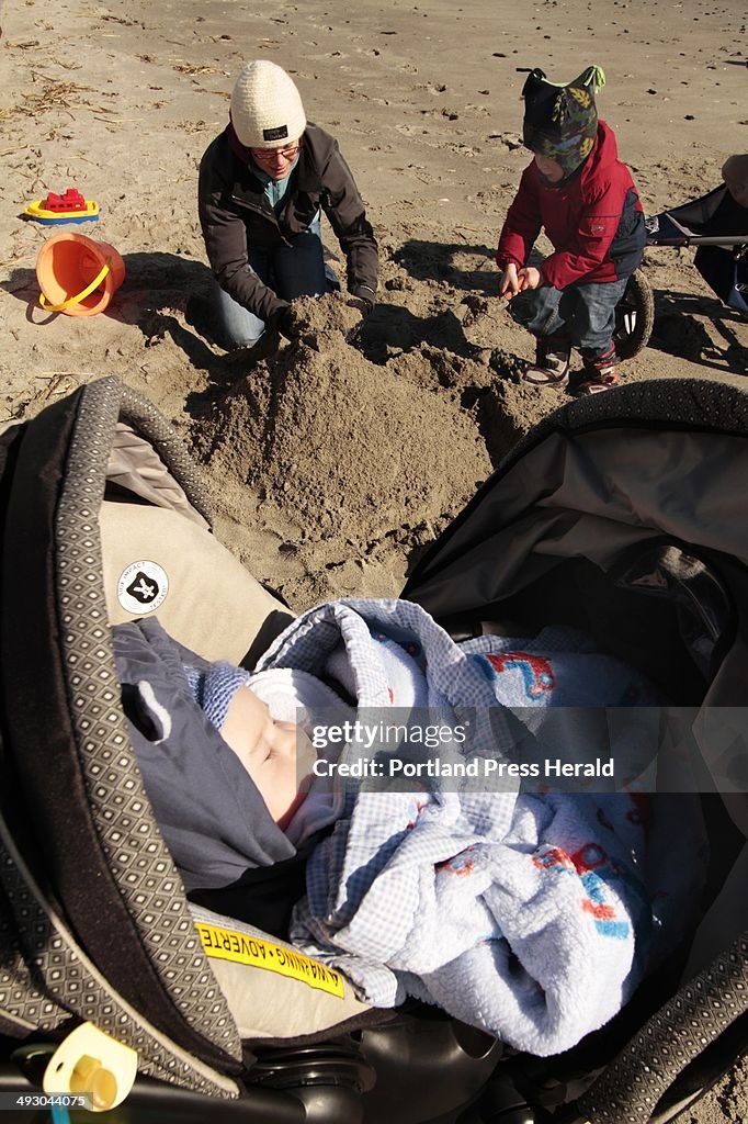 Nine week-old Oliver Vinson takes a nap in his stroller as cousin Ethan Moore and aunt Heather Moore